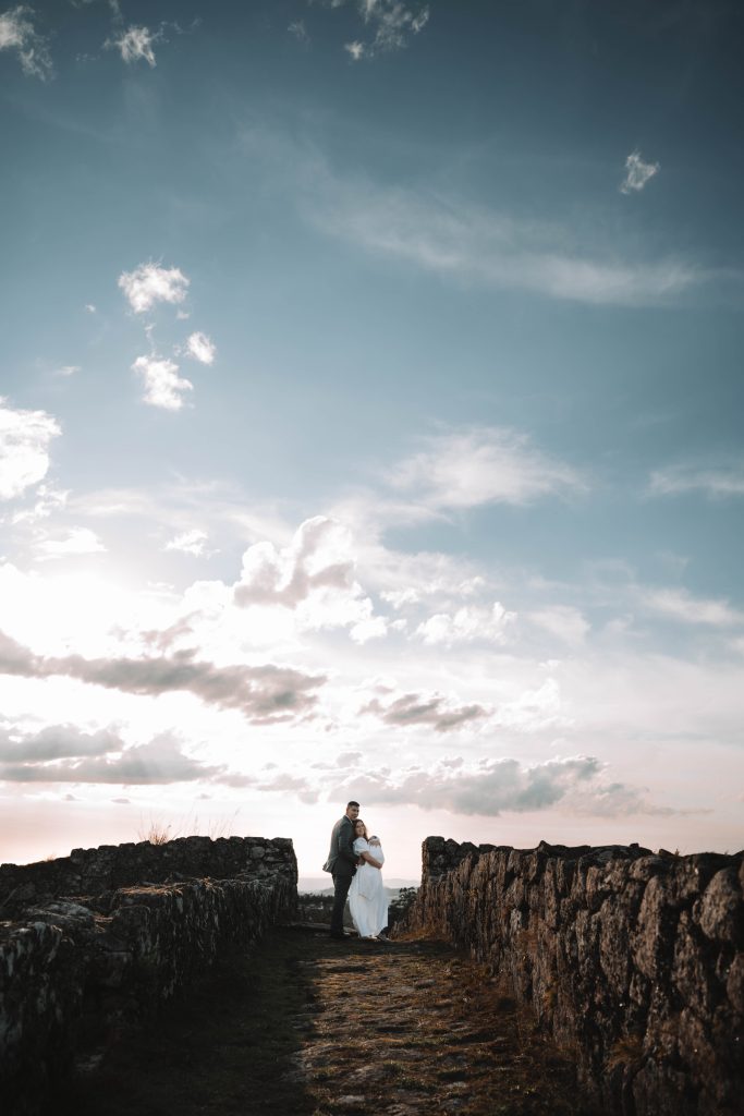 Casal abraçado ao pôr-do-sol com a filha
