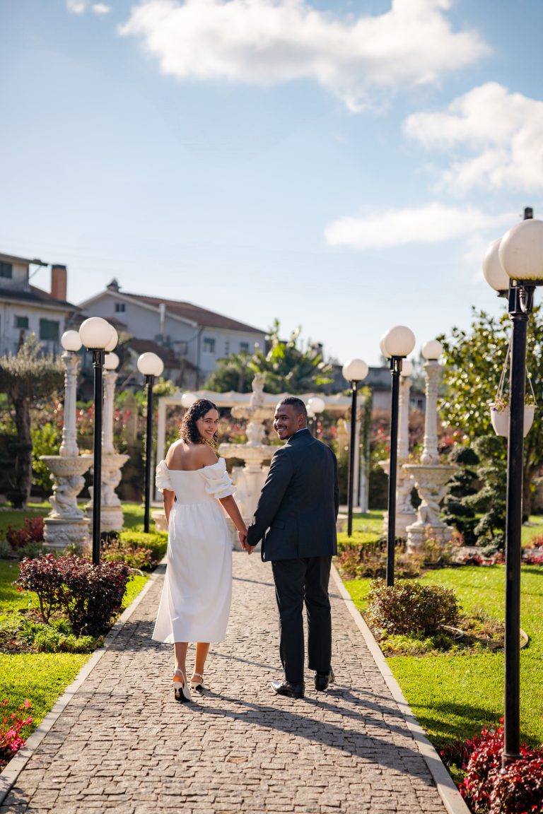 Casal de mãos dadas a caminhar numa quinta