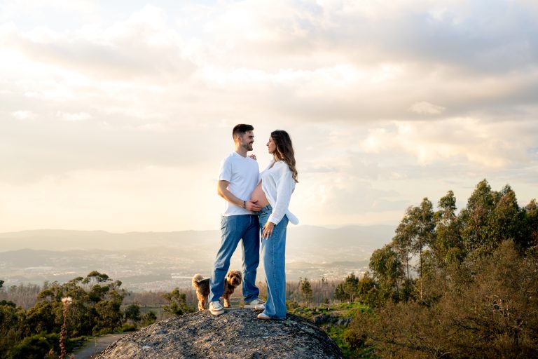Casal com a mão na barriga da grávida ao pôr-do-sol